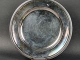 une assiette ancienne en argent, ornée d'un liseré en relief sur le bord