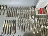 a lot of silverware on a table with a box