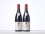 two bottles of red wine sitting on top of a table