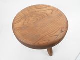 a small wooden stool with a wooden seat on a white surface