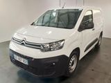 La camionnette blanche est garée dans le garage, tous phares allumés.