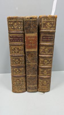 trois vieux livres sont empilés sur une table