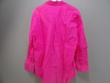 a pink shirt hanging on a hanger against a wall