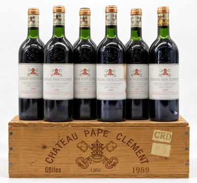 six bouteilles de Château Pape Clément dans une caisse en bois