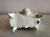 a small figurine of a sheep sitting on a table