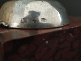 a silver plate sitting on top of a piece of wood