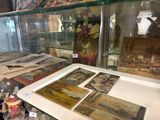 une vitrine remplie de tableaux et de vases