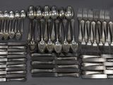 de nombreuses fourchettes et cuillères disposées sur la table