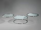 trois tables basses en verre avec des pieds argentés et un plateau blanc