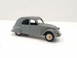 grey toy car on a white surface with a white background