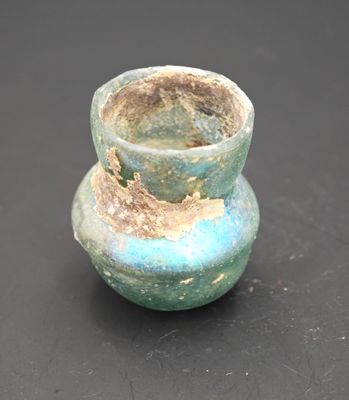 un petit vase vert posé sur une table