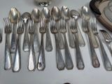 a lot of silver spoons and forks on the table