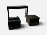 a black table with a mirror on it and a small table with a drawer underneath it