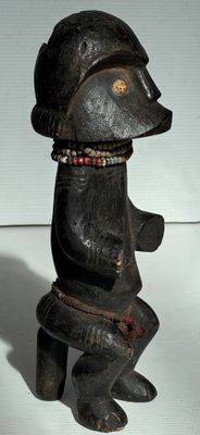 une petite statue représentant un ours coiffé d'un chapeau