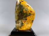 sculpture en marbre représentant une pierre jaune et noire posée sur un socle noir
