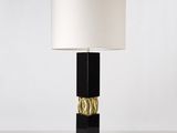 a black table lamp with a white shade on top of it