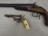 an old gun and a revolver are on a tile floor