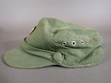 a green hat with googly eyes sitting on a table