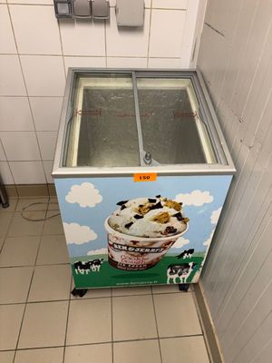 an ice cream machine with a cow on it in a stall