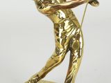 statue d'un homme brandissant un club de golf, posée sur un socle doré
