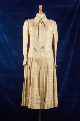 une robe posée sur un mannequin, devant un fond bleu