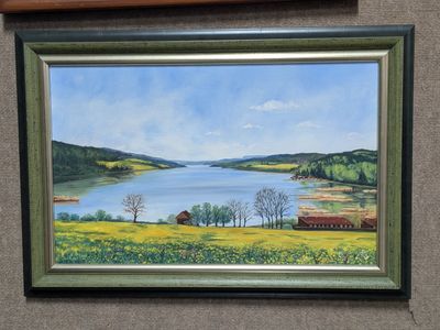 tableau à l'huile encadré représentant un lac avec une grange au loin