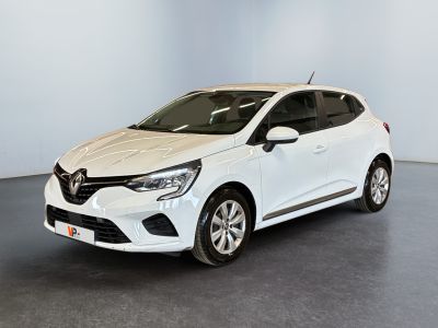 Une voiture blanche est garée dans une pièce au sol noir