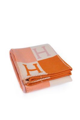 an orange and white blanket with the letter h on it