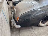 an old car that is parked next to a wall
