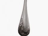 a silver spoon with a bird on it on a white surface