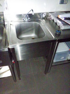 deux éviers dans la cuisine avec une poubelle posée sur le plan de travail