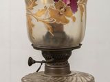 a glass vase on a metal stand with flowers on it
