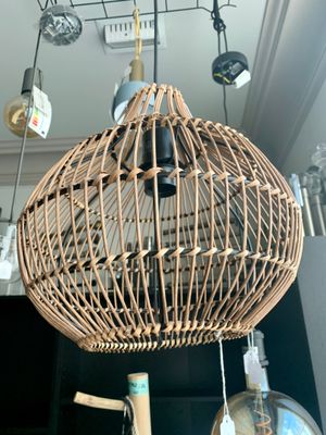 une lampe en osier suspendue au plafond dans une pièce