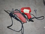 a red and black blow dryer sitting on the ground