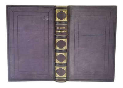 un livre violet aux bords dorés et à la couverture noire
