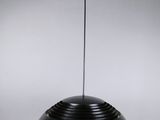 une lampe noire suspendue au plafond, sur laquelle se trouve une araignée
