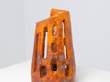 an orange vase sitting on top of a white table