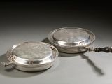 pair of silver plated serving dishes with handles on a table