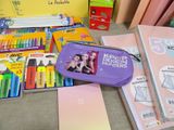 several school supplies are laid out on a table in front of a yellow box