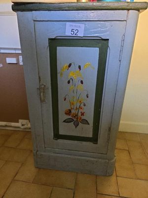 a cabinet with a painting on it in a room