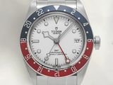 a silver watch with a red and blue bezel on it