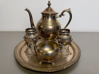 a silver tea set on a silver tray on a table