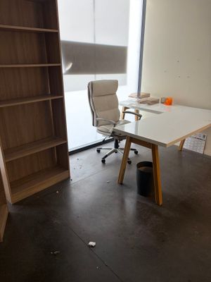 un bureau avec une chaise et une bibliothèque dans un coin