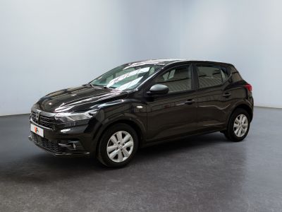 Une voiture noire est garée dans une pièce aux murs blancs.