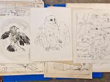 une pile de dessins posée sur une table, à côté d'une pile de papiers