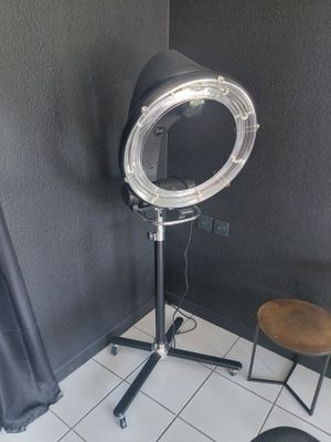 a hair dryer sitting on a stand next to a stool