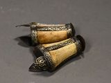 two pieces of ivory and silver on a table
