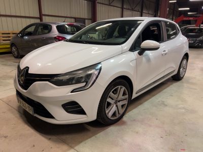 La voiture blanche est garée dans un garage, avec d'autres voitures en arrière-plan.
