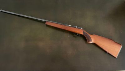a rifle on a table with a black background
