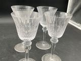 four clear wine glasses sitting on top of a table